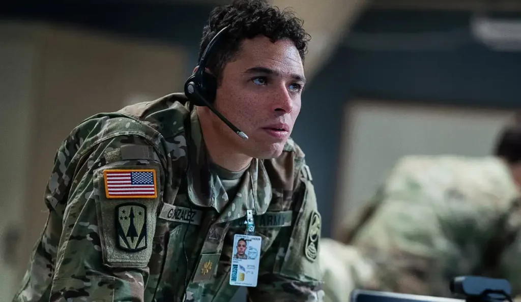 Soldado americano com uniforme camuflado e fone de ouvido concentrado em operação de emergência no filme Casa de Dinamite (2025).
