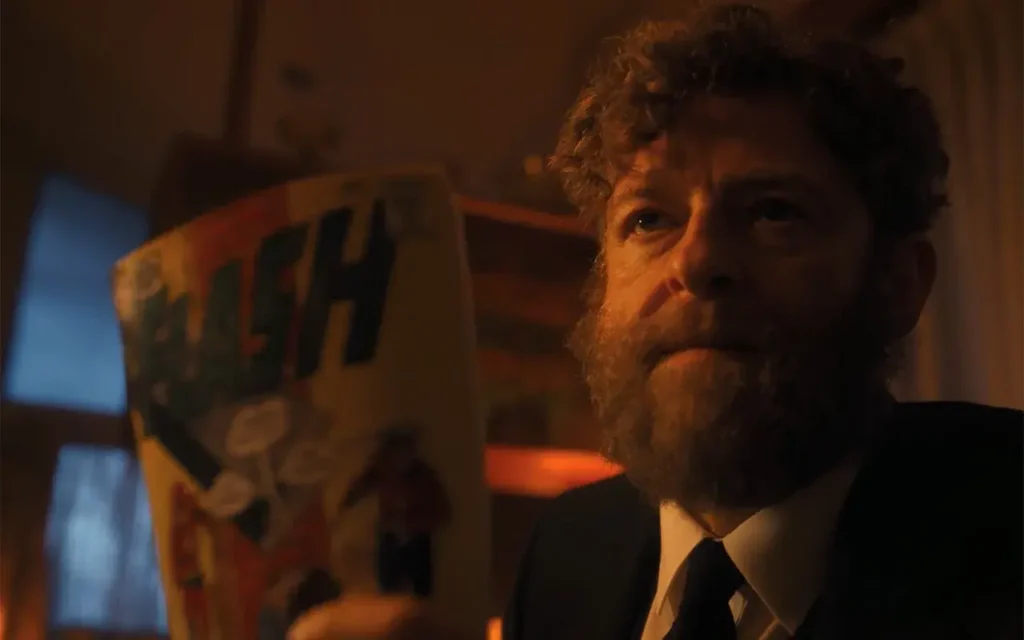 Homem barbudo segura o gibi The Flash #123 em cena do primeiro episódio de IT: Bem-Vindos a Derry