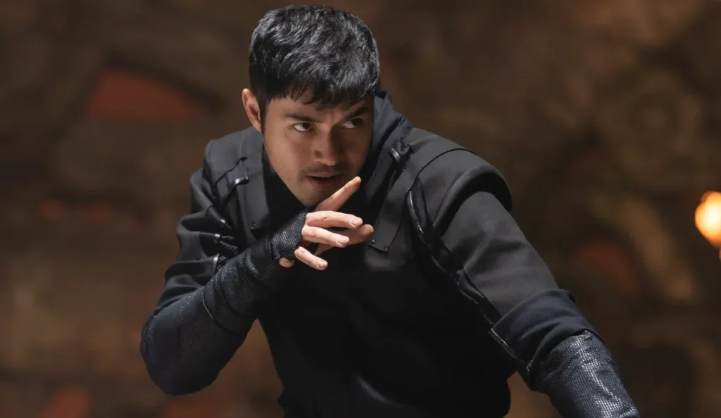 Henry Golding em cena de luta intensa como Snake Eyes, cercado por guerreiros do clã Arashikage.