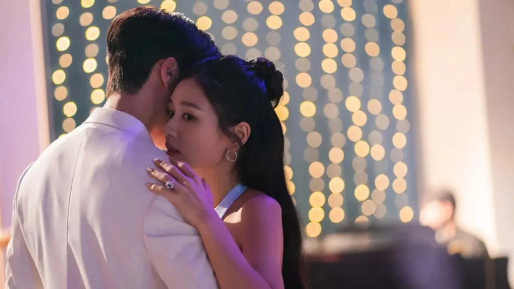 Ahn Eun-jin abraça Jang Ki-yong em uma cena romântica com luzes desfocadas ao fundo no dorama Beijo Explosivo