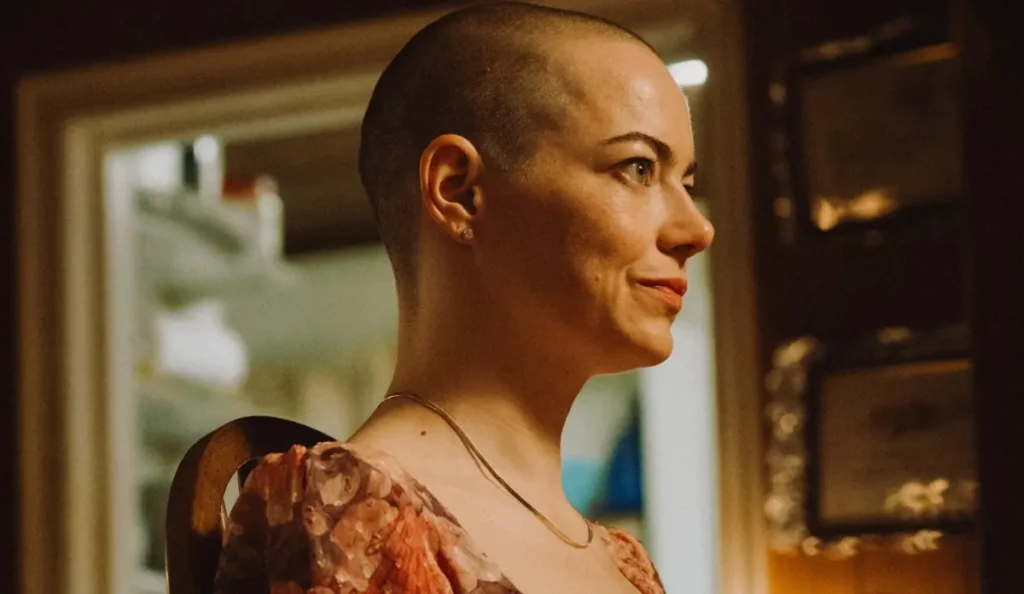 Emma Stone em cena de Bugonia observando o cenário ao redor