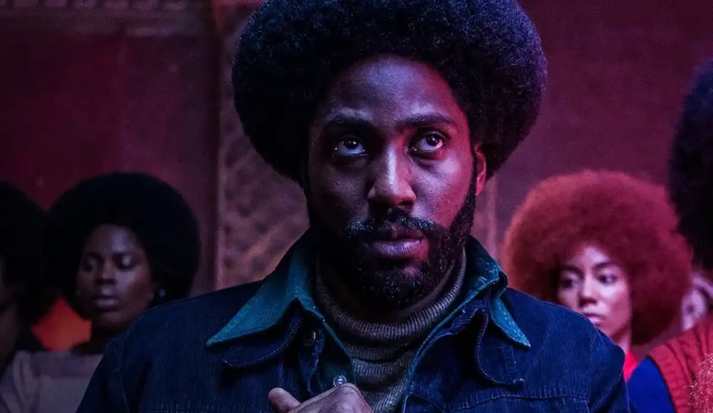 Ron Stallworth encarando documentos da investigação em Infiltrado na Klan