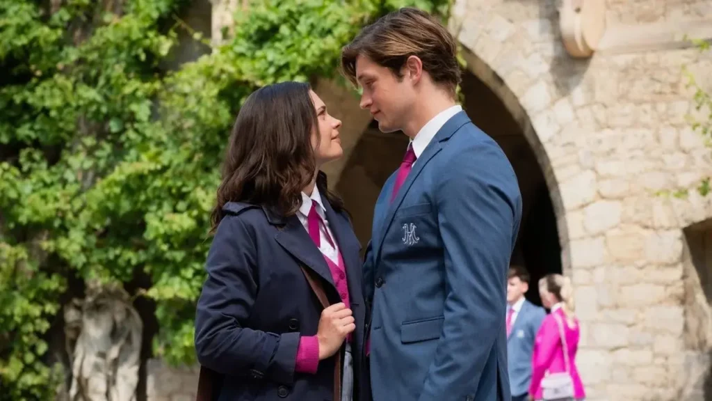 Ruby e James se encaram de perto no pátio da escola usando uniforme azul e rosa de Maxton Hall