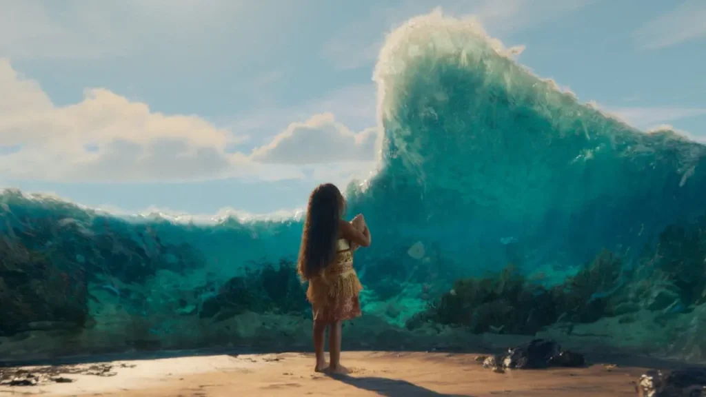 Cena do live-action de Moana mostrando a personagem criança diante de uma grande onda se abrindo no oceano