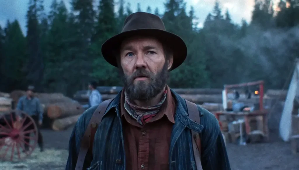 Sonhos de Trem final explicado: o simbolismo por trás do desfecho do filme da Netflix Robert em área de corte de madeira em cena do filme Sonhos de Trem