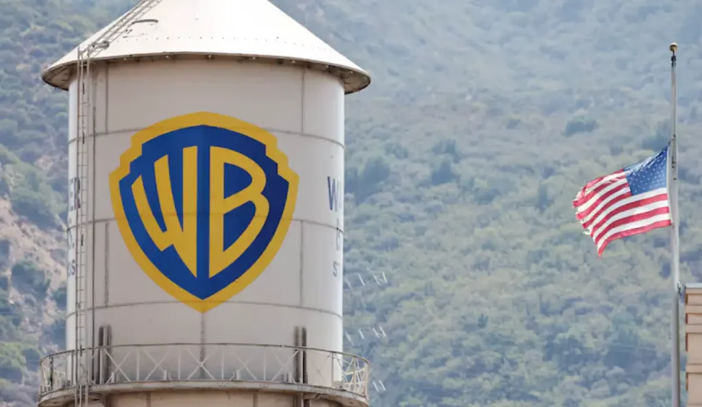 Fachada do estúdio Warner Bros com o logotipo dourado, representando a disputa pela compra da empresa
