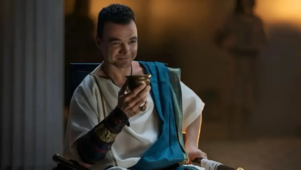 Ashur sentado em ambiente romano luxuoso em cena da série Spartacus House of Ashur do MGM+