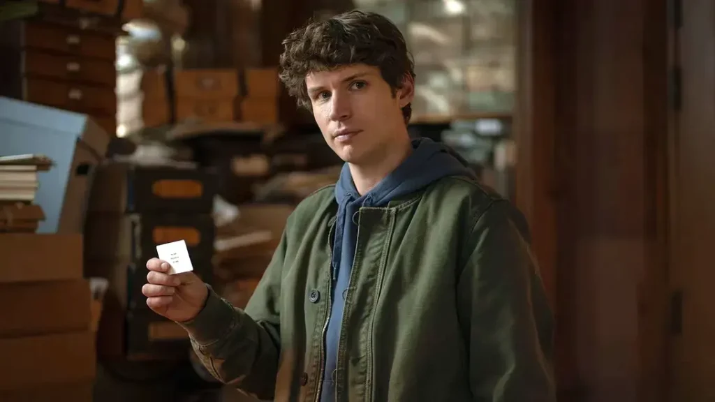 Guy Anatole segurando um cartão na série Talamasca na série Talamasca: A Ordem Secreta