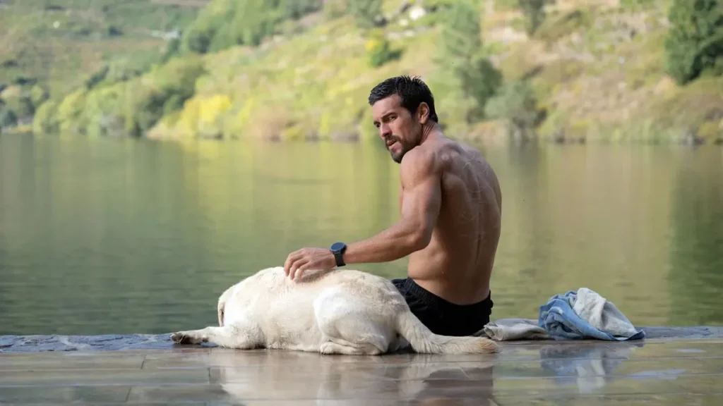 Mario Casas como agente Zeta em momento introspectivo à beira de um lago em cena do filme