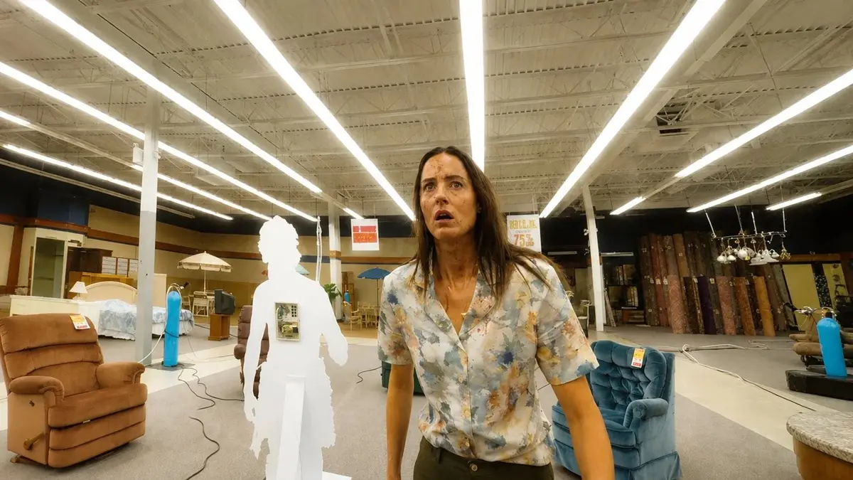 Mary observa um ambiente amplo e distorcido dentro das Backrooms em cena do filme Backrooms: Um Não-Lugar.