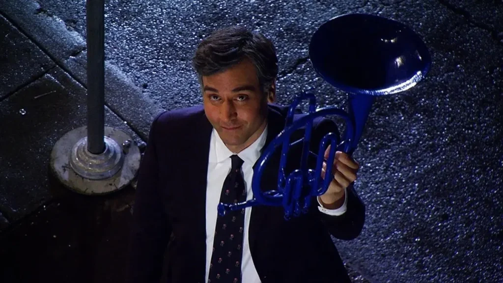 Cena da série How I Met Your Mother mostra Ted segurando a trompa azul em uma rua à noite