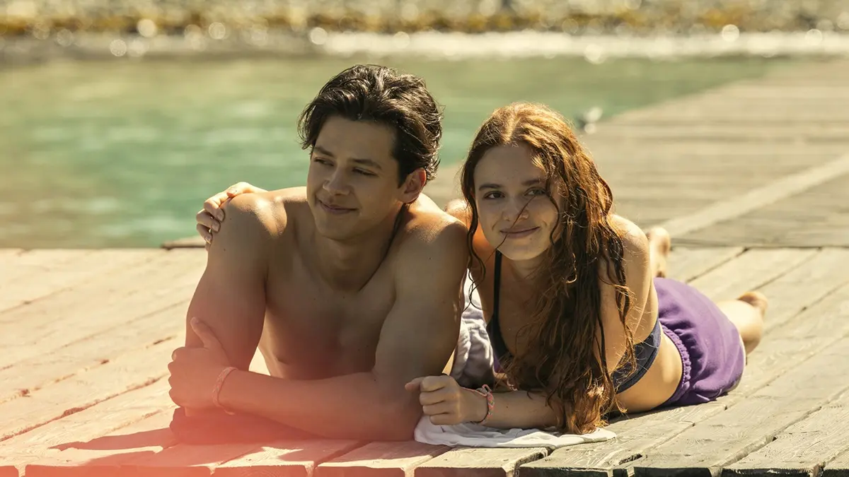 Cena da série Depois Daquele Ano mostra casal protagonista deitado em um píer à beira do lago