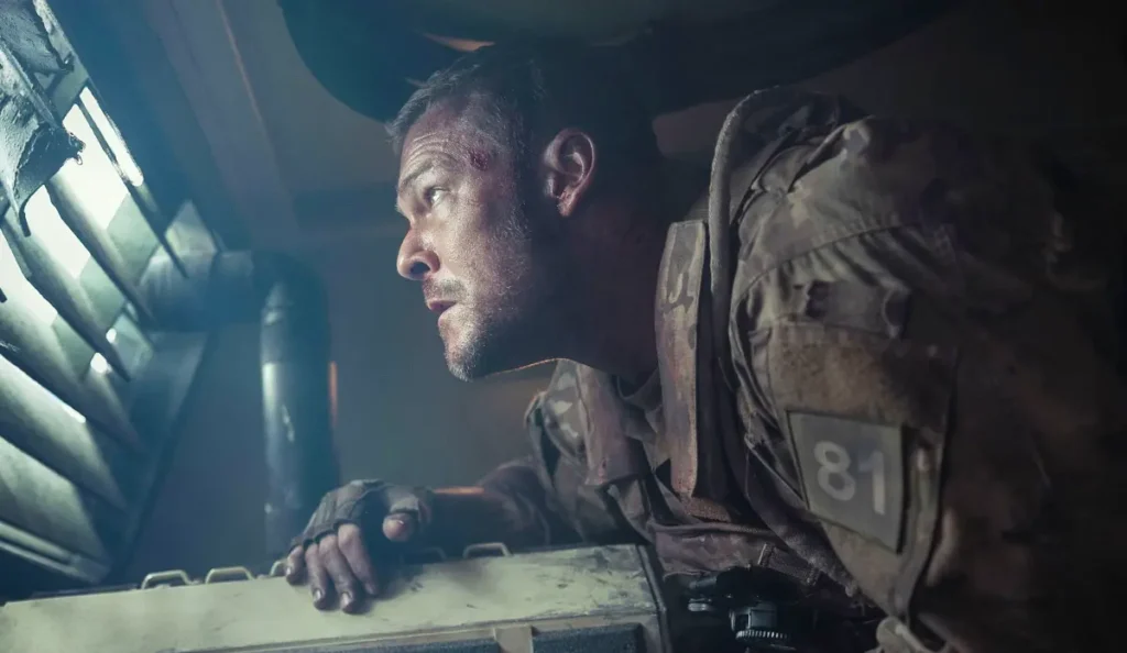 Alan Ritchson em cena de ação no filme Máquina de Guerra, da Netflix