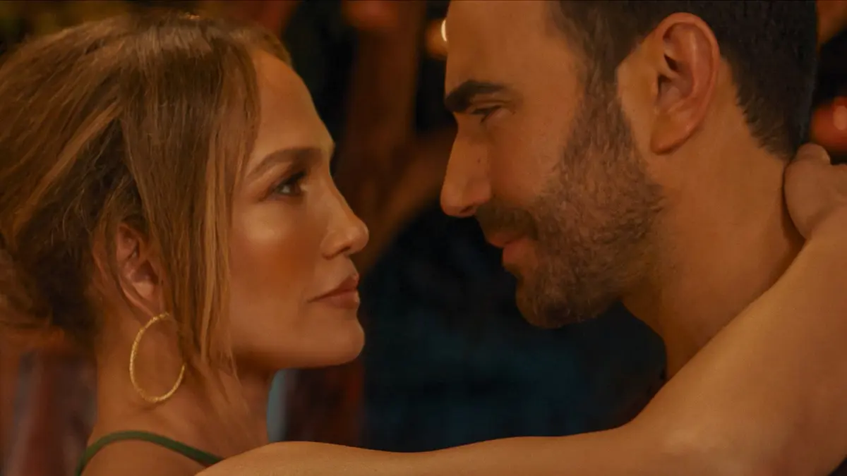 Jennifer Lopez e Brett Goldstein aparecem em cena de escritório no filme Paixão de Escritório, da Netflix
