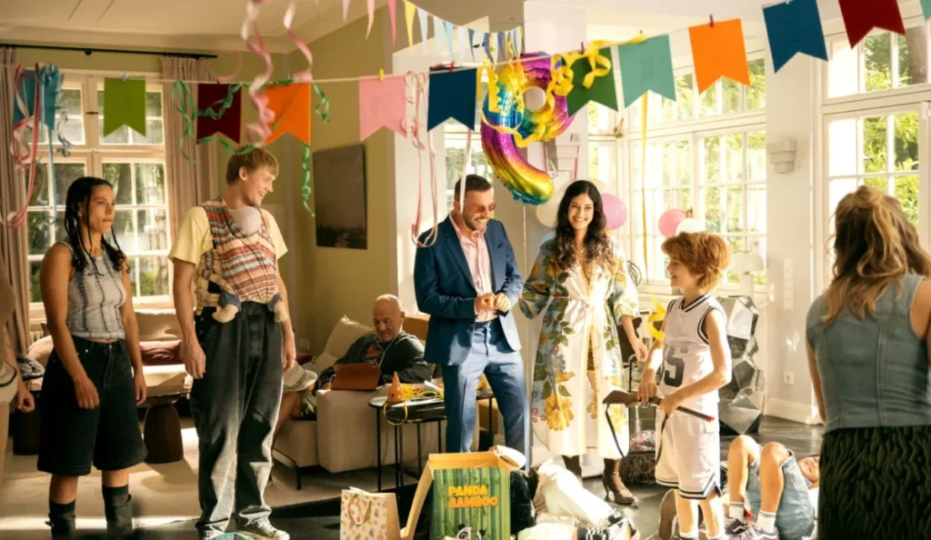 Familiares e convidados reunidos durante a festa de aniversário no filme O Presente de Aniversário